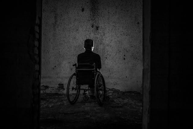 person in wheelchair in dark room