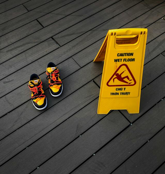 wet floor sign next to pair of shoes