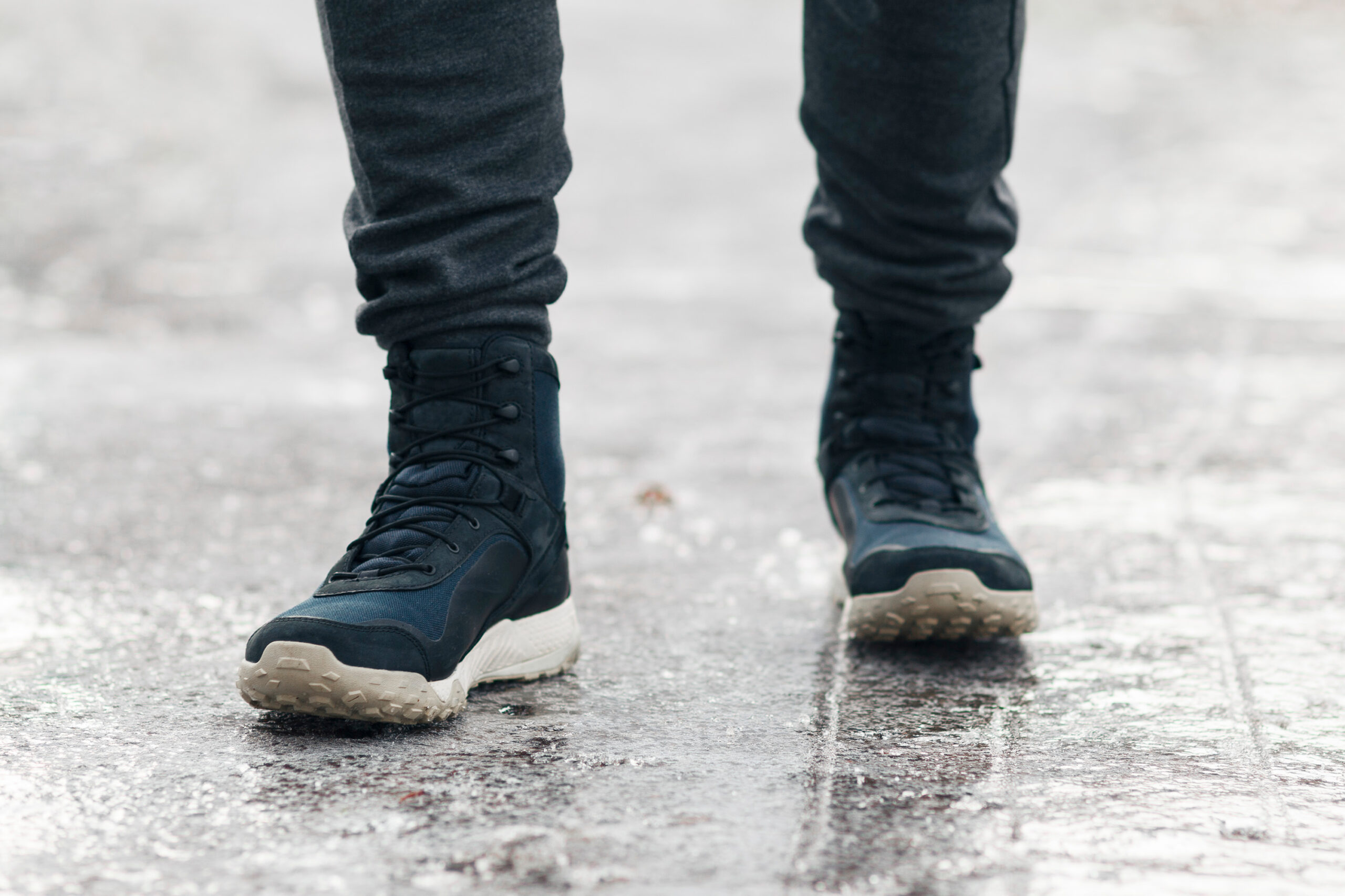 People slides on path. Icing on sidewalk, slippery ice-crusted ground.